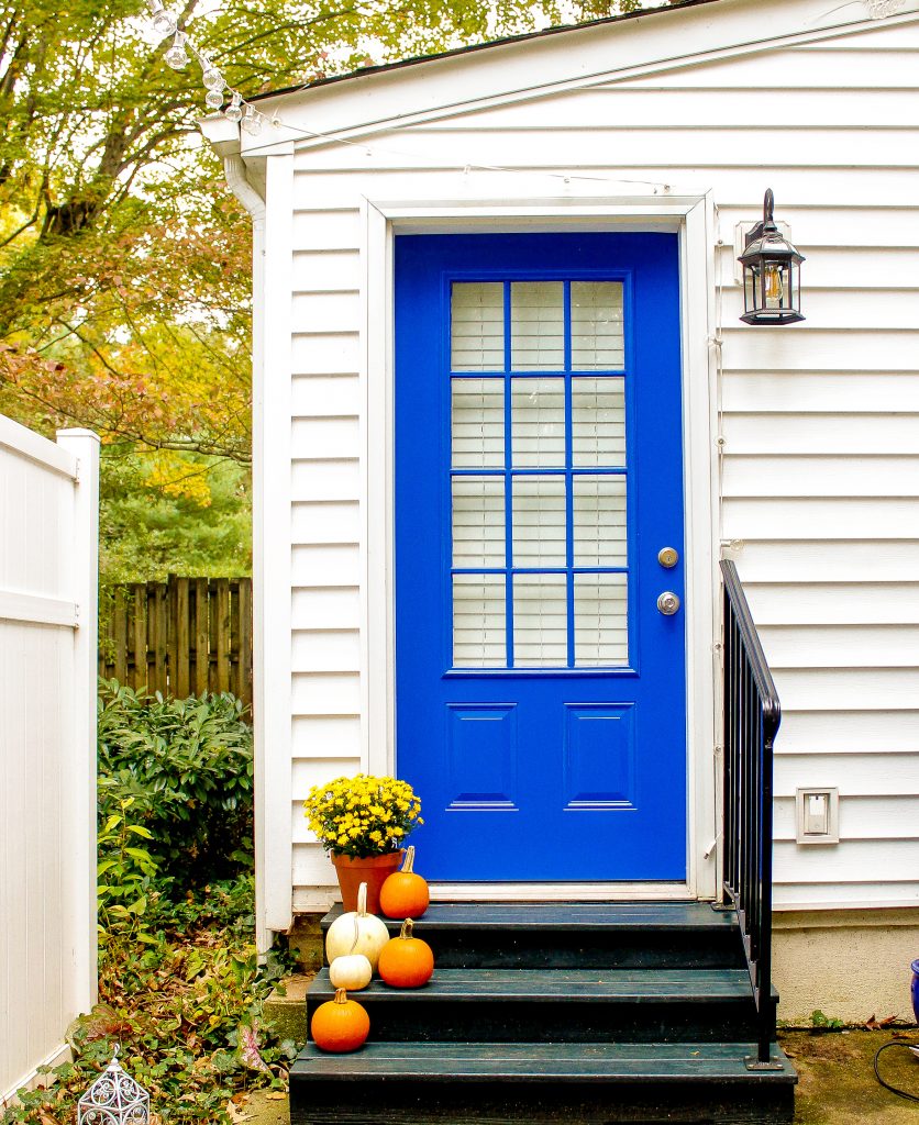 The after picture shows our bright blue door and updated light fixture just after our back porch makeover.
