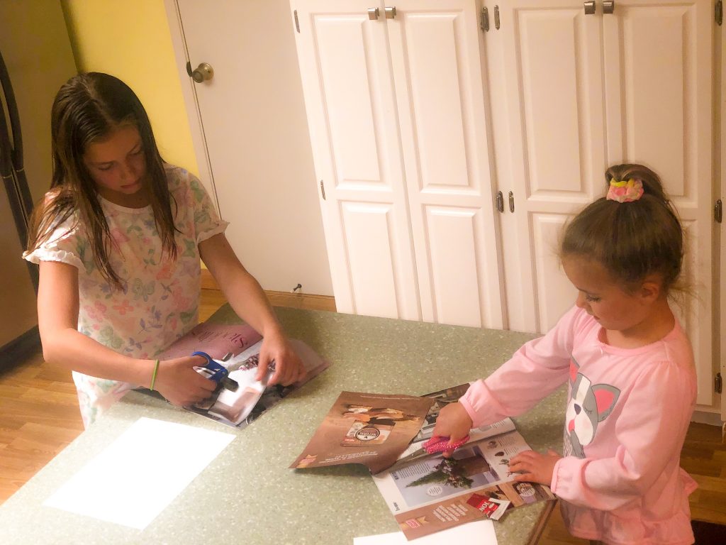 little girls cutting pictures out of magazines