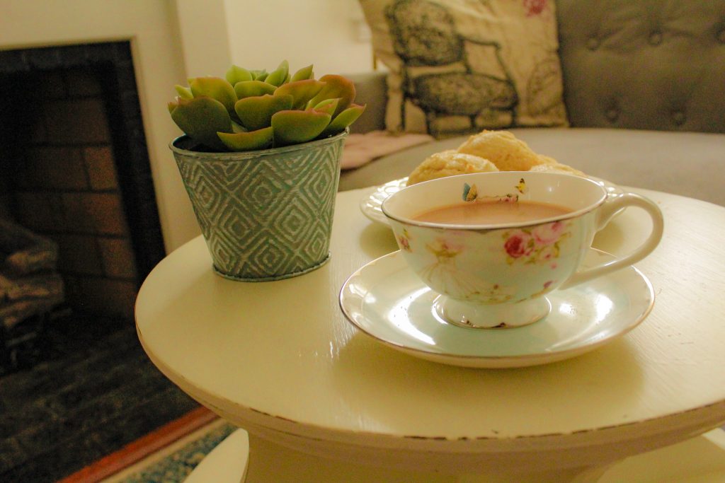 tea cup with cookies and a plant in the background