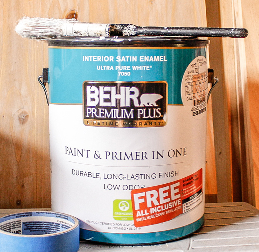 can of paint for the office closet with paint brush on top and roll of painter's tape on the side